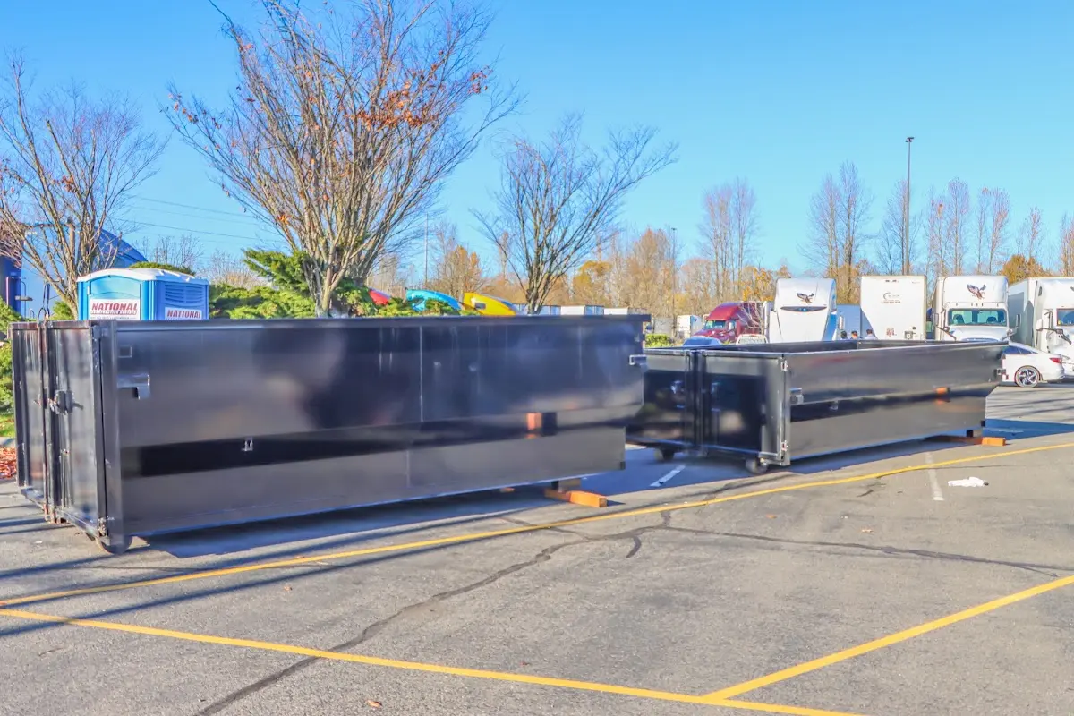 Professional dumpster rental service with roll-off container on residential driveway in Harrison